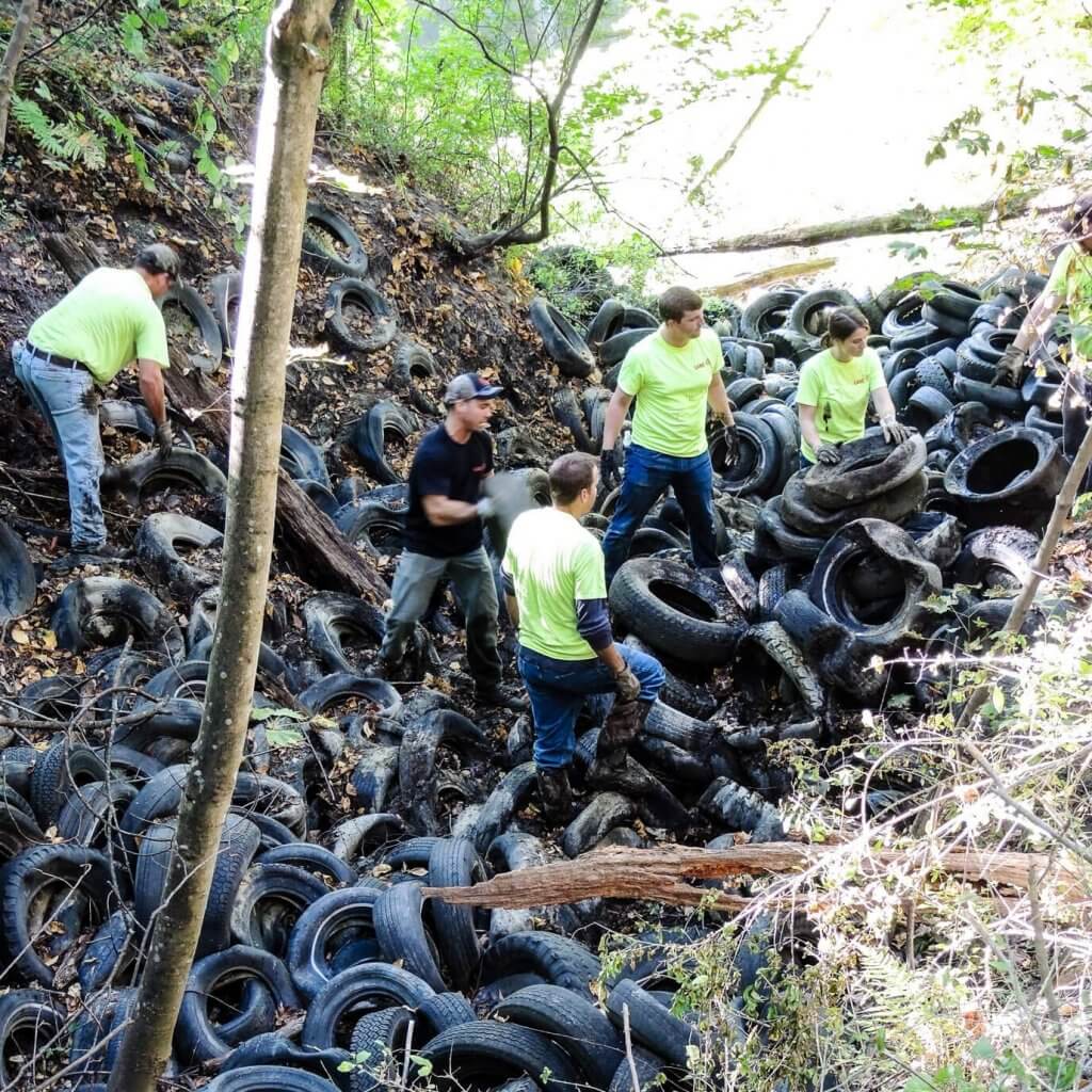 volunteers removing pile of tires
